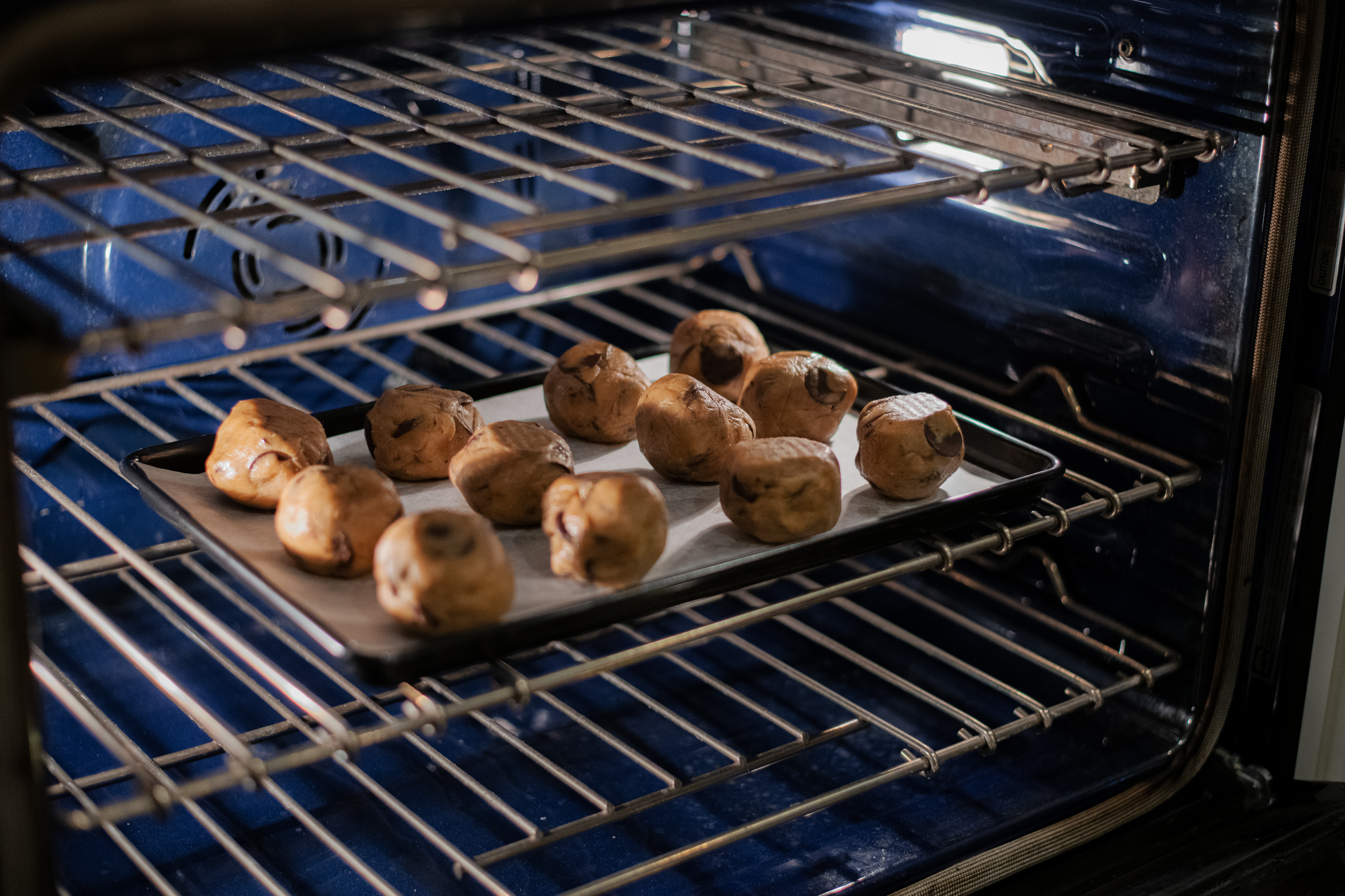 Chocolate chip cookie balls being baked in the oven